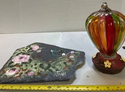 glass hummingbird feeder and painted hanging rock